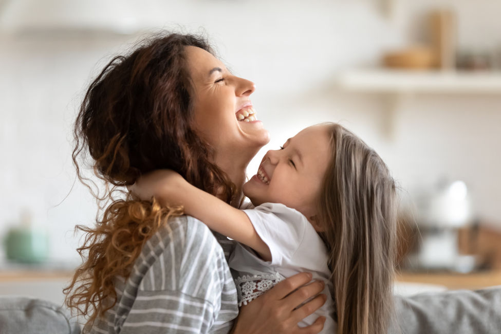 Mother and daughter hugging and laughing
